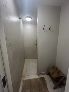 Enkelt men funktionellt duschrum på Örnvikens Glamping med bänk och krokar