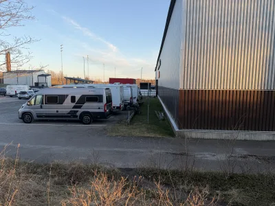 Frizze på ställplats vid Norrtälje Sportcentrum i kvällsljuset tillsammans med andra husbilar