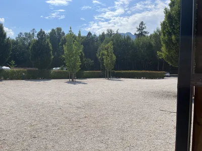 Vi hittade en rymlig grusplan med gröna träd och berg i bakgrunden