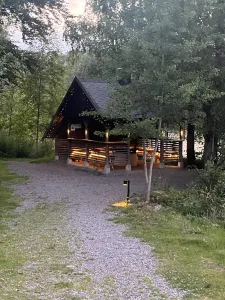 En mysig upplyst grillkoja av timmer välkomnade oss på ställplatsen i skogsmiljö